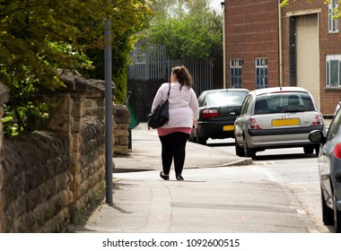 Nottingham, Nottinghamshire, UK, 05/15/2017, A Solitary Obese Woman Seen From Behind Walking On A Sidewalk.