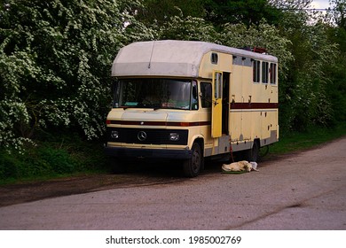 NOTTINGHAM, UNITED KINGDOM - May 18, 2021: Dog relaxing in the sun in front of an old Vintage, Converted horsebox, Mobile home, 