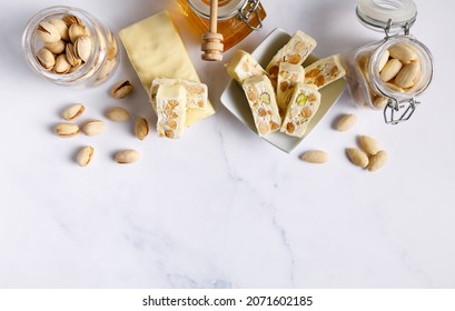 Nougat with pistachios and almonds. These delicious confections are filled with the dried almonds and pistachio nuts and covered with white chocolate. - Shutterstock ID 2071602185