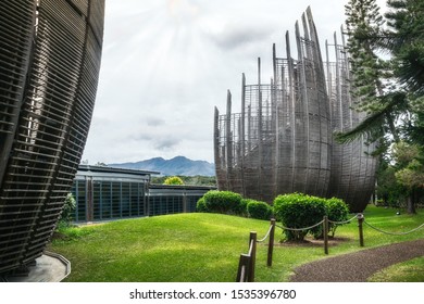 Noumea, New Caledonia -August 4, 2019: Mountain view with some of the building's airy shell structures at the Tjibaou Cultural Centre, a native art museum in Noumea, New Caledonia. 