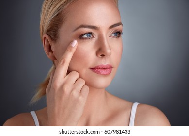 
Nourished Middle Age Woman Looking At Wrinkles Around The Eyes