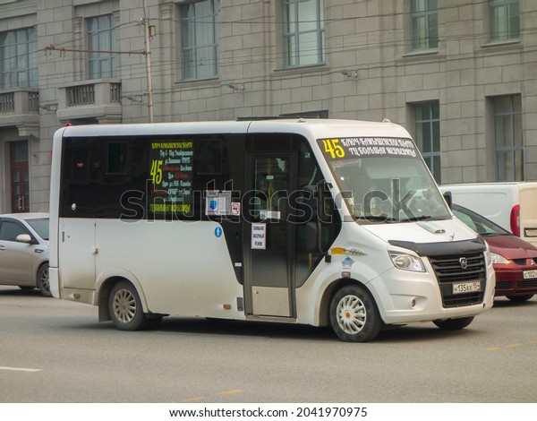Nov1osibirsk, Russia, april 27 2021: white color\
new public private small russian city line route frame GAZ Gazelle\
Next with plate, charter service mini bus transfer delivery drive\
on urban street