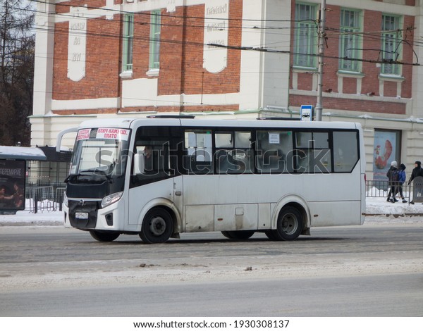 Nov1osibirsk, Russia - february 09 2020: white\
metallic color new private small russian city line bus PAZ\
320435-04 Vector Next , charter service mini bus transfer delivery\
drive on winter\
street