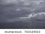 nov2017,Solomon Islands, Honiara, Guadalcanal, Iron Bottom Sound, a lonely ship sits in front of the volcanic island of Savo under a cloudy sky, where the battle that ended the second WW was fought