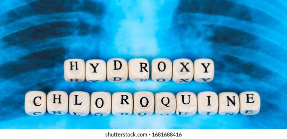 Novel Covid-19, Coronavirus. Infected Lungs Radiology Blue Image Background, With White Pills On It. Hydroxy Chloroquine Written With Wooden Letters.