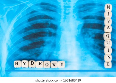 Novel Covid-19, Coronavirus. Infected Lungs Radiology Blue Image Background, With White Pills On It. Hydroxy Chloroquine Written With Wooden Letters.