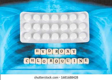 Novel Covid-19, Coronavirus. Infected Lungs Radiology Blue Image Background, With White Pills On It. Hydroxy Chloroquine Written With Wooden Letters.