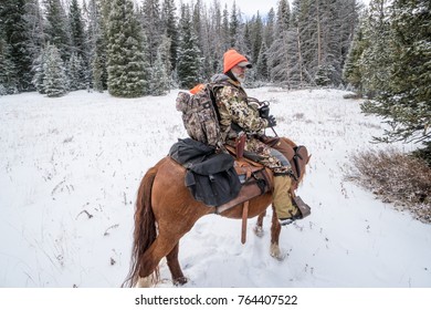 NOVEMBER 10 2017 - DILLON, MT: Mature Adult Man On Horseback With Deer Hunting Gear, Preparing To Ride In The Montana Wilderness On A Snow Covered Trail In The Winter