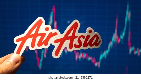 November 10, 2021, Kuala Lumpur, Malaysia. AirAsia Emblem Against The Background Of A Share Price Chart.