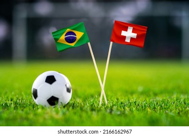 November 2022, Brazil Vs. Switzerland, Football Match Wallpaper, Handmade National Flags And Soccer Ball On Green Grass. Football Stadium In Background. Black Edit Space.