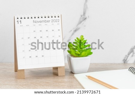 The November 2022 desk calendar with plant on wooden table. Photo stock © 