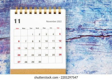 November 2022 Monthly Desk Calendar For 2022 Year On Old Blue Wooden Background.