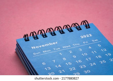 November 2022 - small spiral desktop calendar against textured  paper, low angle macro shot, time and business concept