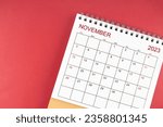 November 2023 desk calendar on red color background.