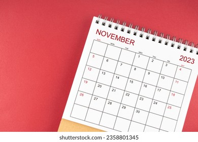November 2023 desk calendar on red color background.