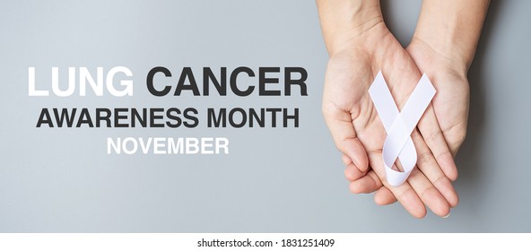 November Lung Cancer Awareness month, .Man holding white Ribbon on grey background