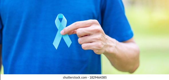 November Prostate Cancer Awareness month, Man in blue T shirt with hand holding Blue Ribbon for supporting people living and illness. Healthcare, International men, Father and World cancer day concept