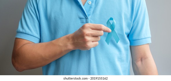 November Prostate Cancer Awareness month, Man in blue shirt with hand holding Blue Ribbon for supporting people living and illness. Healthcare, International men, Father and World cancer day concept