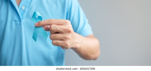 November Prostate Cancer Awareness month, Man in blue shirt with hand holding Blue Ribbon for supporting people living and illness. Healthcare, International men, Father and World cancer day concept