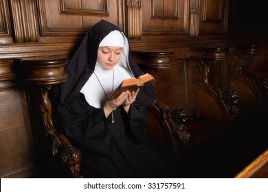 Novice nun reading a prayer book (shot in a 17th century church interior, all clothing and accessories authentic or antique)