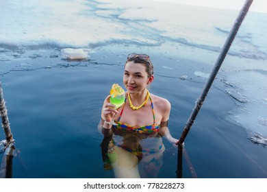 Novokuznetsk, Kemerovo region, Russia - 23 Feb, 2017 : White beaches of Siberia is an enterteiment activity where people playing beach games dressed in bikini in winter. Woman in an ice hole