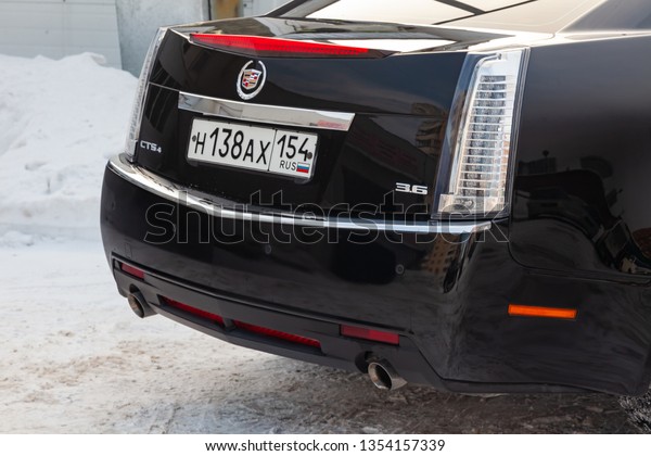 Novosibirsk, Russia - 03.10.2019: Rear bumper\
and trunk view of Cadillac CTS in black color after cleaning before\
sale in a winter day and snow\
background