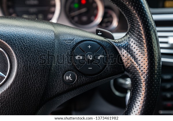 Novosibirsk, Russia -\
04.12.2019: The interior of the car Mercedes Benz E-class E250 with\
a view of the steering wheel, hands-free and volume buttons with\
light gray trim