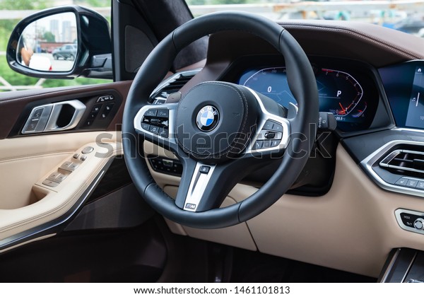 Novosibirsk, Russia -\
07.20.2019: View to the white and brown interior of BMW X7 M\
Performance with dashboard, media system, display, front seats,\
steering and shiftgear  on\
parking