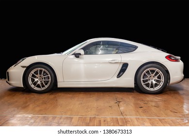 Novosibirsk, Russia - 08.01.18: Side View Of Luxury Very Expensive New White Porsche Cayman Coupe Sportcar Stands In The Detailing Box Waiting For Repair In Auto Service Against Black Wall