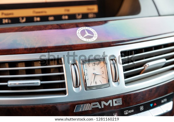 Novosibirsk, Russia - 08.01.2018: The central control\
console in the interior of the car Mercedes Benz model AMG with a\
clock face on the panel and elements of wood and chrome close-up\
brand symbol 