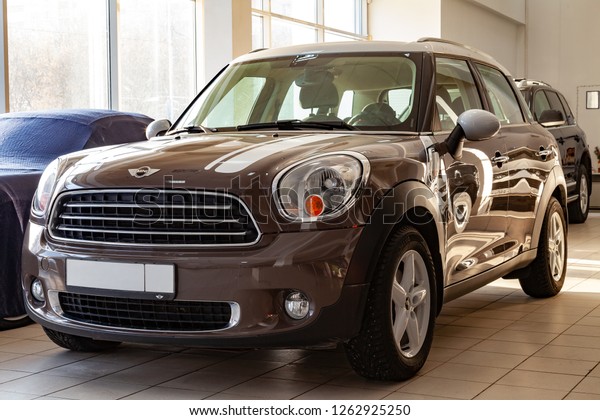 Novosibirsk, Russia - 08.01.2018: An expensive car,\
a female model of a mini cooper beige and gold color and a white\
roof polished and shiny is set up in a car center for sale or\
purchase as a gift