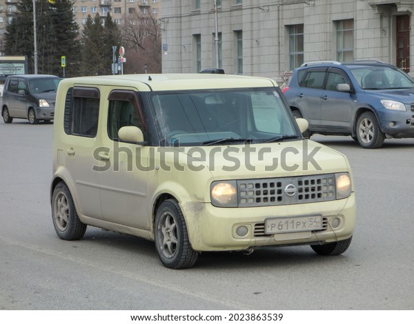 Novosibirsk, Russia - April 02 2021: private\
yellow japanese small cheap hatch car Nissan Cube II 2, popular\
economy budget square old hatchback export import made in Japan\
drive on urban city\
street