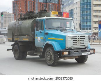 Novosibirsk, Russia - April 14 2021: Blue Color Russian Fuel Petroleum Water Tanker Truck Car Chassis ZiL 4333 4331, Popular Small Cargo Mini Old Truck 80s 90s 2000s Drive On City Urban Dusty Street 