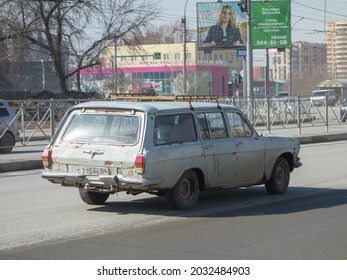 Novosibirsk, Russia - April 14 2021: Gray Metallic Color Russian USSR Rwd Drive Old Classic Vintage Station Wagon 60s 70s 80s GAZ 2402 Volga Made In Soviet Union Drive On City Urban Broad Dirty Street