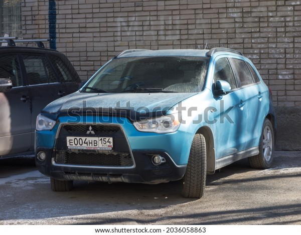 Novosibirsk, Russia - april 22 2021: private awd\
blue metallic all-wheel drive japanese small crossover basic cheap\
Mitsubishi ASX (RVR), popular used old SUV car made in Japan on\
urban sunny street