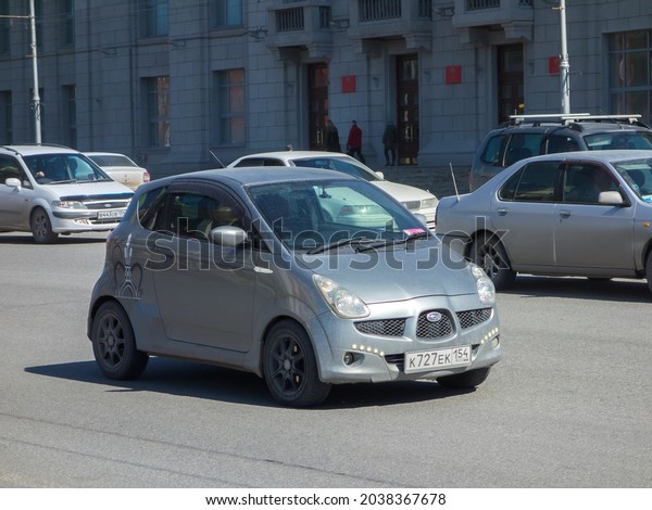 Novosibirsk, Russia - April 23 2021: private dark\
silver gray metallic color japanese small hatchback rare key car\
Subaru R1 2000s 00s, economy cheap hatch made in Japan drive on\
urban city street