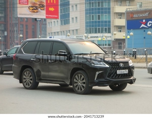 Novosibirsk, Russia - april 27 2021: private\
all-wheel drive black styling metallic color japanese big frame\
luxury SUV Lexus LX 570 Superior, popular luxury car crossover\
drive on broad city\
street