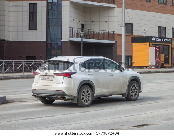 Novosibirsk, Russia - April 29 2021: private all-wheel\
drive 4wd 4x4 white pearl metallic color japanese SUV dirty Lexus\
NX 300 facelift, popular new car crossover driving city urban broad\
street 