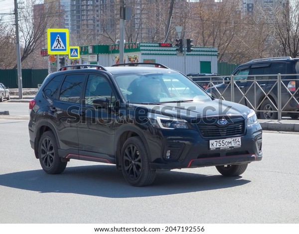 Novosibirsk, Russia - April 30 2021: private awd\
all-wheel drive black metallic japanese family midsize SUV Subaru\
Forester Sport SK, new car business class crossover made in Japan\
driving on street
