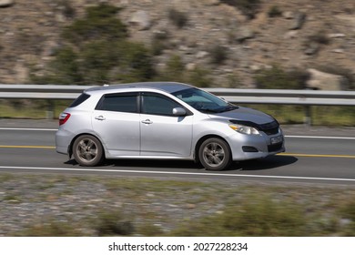 Novosibirsk, Russia - August 08, 2021:   
Silver Toyota Matrix Driving Fast On Freeway In Highlands On Summer Day On Background Forest