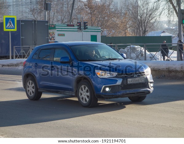 Novosibirsk, Russia - February 01 2021: private\
awd dark blue metallic all-wheel drive japanese small crossover\
basic Mitsubishi ASX facelift, popular SUV car made in Japan on the\
winter urban\
street