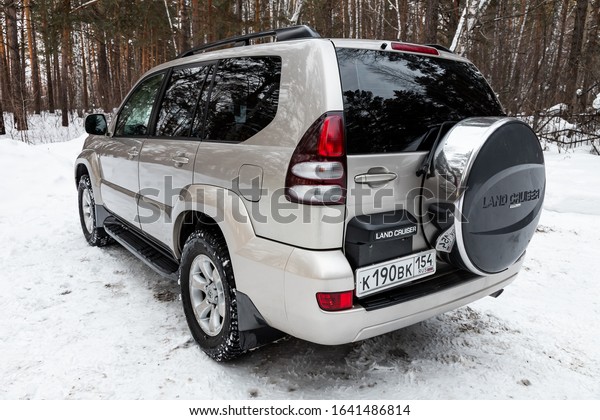 Novosibirsk, Russia\
– February 10, 2020:   silver Toyota Land Criuser Prado, back view.\
 Photography of a modern popular jeep made in Japan standing on a\
snowy street in\
winter