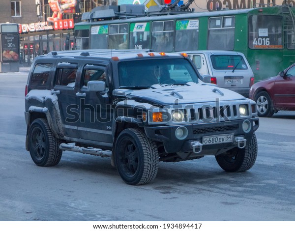 Novosibirsk, Russia - February 12 2021: private\
all-wheel drive black north american frame SUV Hummer H3, popular\
USDM US-spec old car crossover exported from USA on driving the\
winter street
