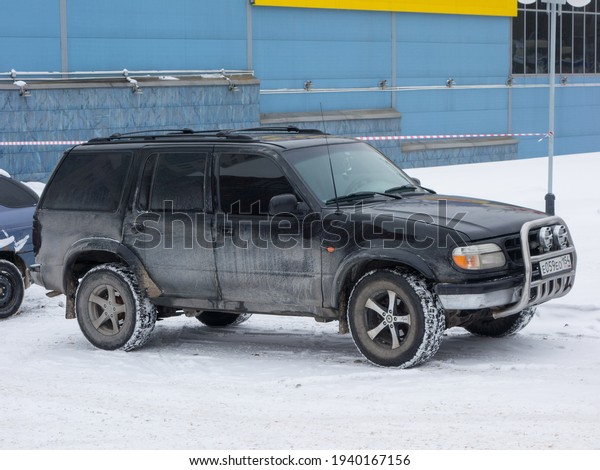 Novosibirsk, Russia - February 16 2021: private\
all-wheel drive black metallic north american frame SUV 90s Ford\
Explorer, popular USDM US-spec old car crossover exported from USA\
on the winter\
street