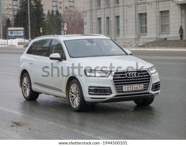 Novosibirsk,\
Russia - February 16 2021: private all-wheel drive white metallic\
color germany sport crossover 4 wd Audi Q7 Quattro , luxury car\
from Germany driving on wet road\
street