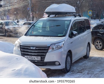 Novosibirsk, Russia - February 23 2020: Private White Metallic Color Passenger Japanese Minivan Car Toyota Noah Hybrid, Station Wagon Van Mini Bus Export From Japan Parking The Snow Winter Street