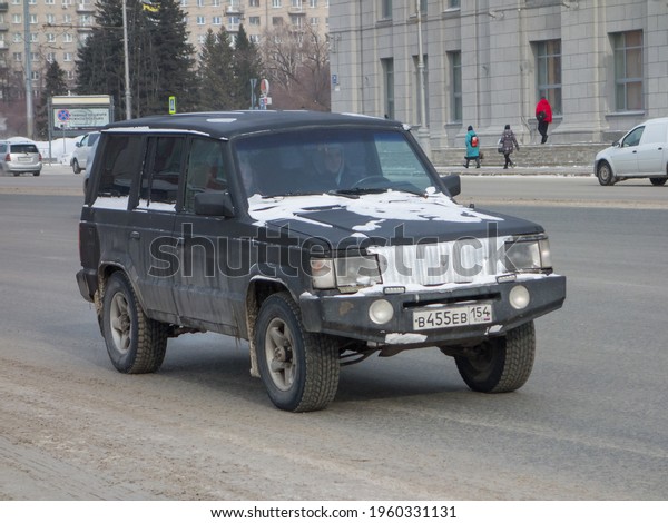 Novosibirsk, Russia - February 26 2021: private\
all-wheel drive black matt color South Korean rare car SUV -\
Ssang-Yong Korando Family,  old vintage crossover  driving on the\
snow winter road street\
