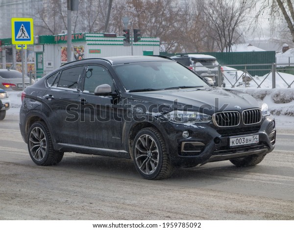 Novosibirsk, Russia - fubruary 26 2021: private\
all-wheel drive black metallic color germany sport coupe crossover\
BMW X6 F16 xDrive30d, luxury car SUV 4wd from Germany driving on\
snow street