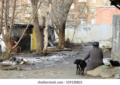 Novosibirsk, Russia - June 03, 2016:an Old Woman Sitting In A Crumbling House In The City With A Dog And A Cat In Novosibirsk, 03 Jun 2016.