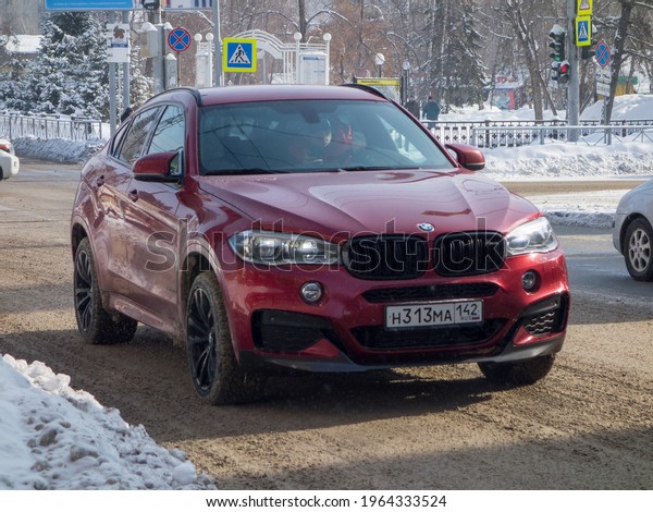 Novosibirsk, Russia - march 03 2021: private\
all-wheel drive dark red metallic color germany sport coupe\
crossover BMW X6 f16 xDrive30d, luxury car SUV 4wd 4x4 from Germany\
driving winter snow\
street